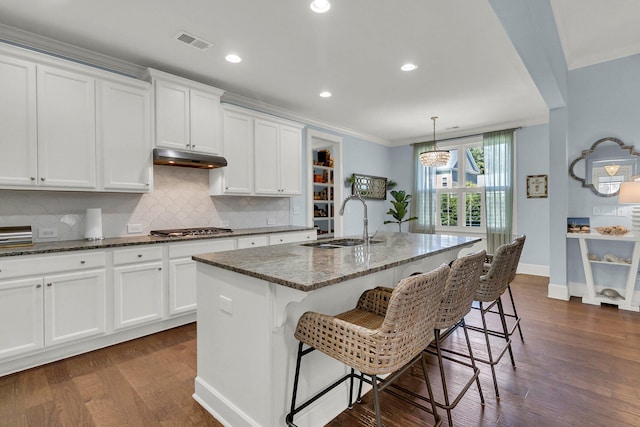 1325 Whisker Pole Ln, Mount Pleasant, SC 29466 - kitchen featuring a sink, stainless steel gas cooktop, dark stone counters, dark wood-style flooring, and crown molding