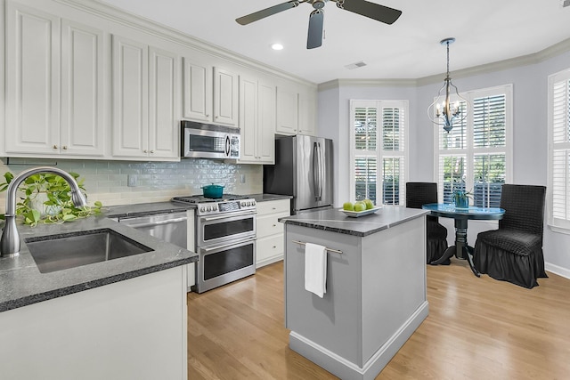 kitchen with white cabinetry, stainless steel appliances, a center island, and light hardwood / wood-style flooring