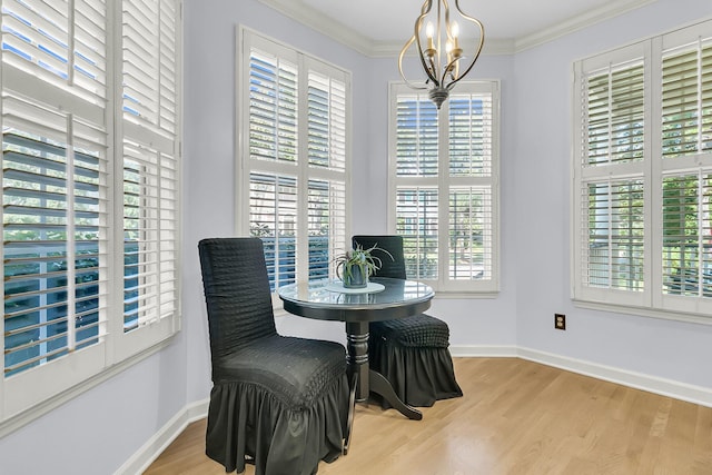 dining room featuring light wood-type flooring, crown molding, and a notable chandelier