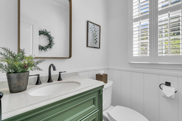 bathroom featuring vanity, toilet, and ornamental molding