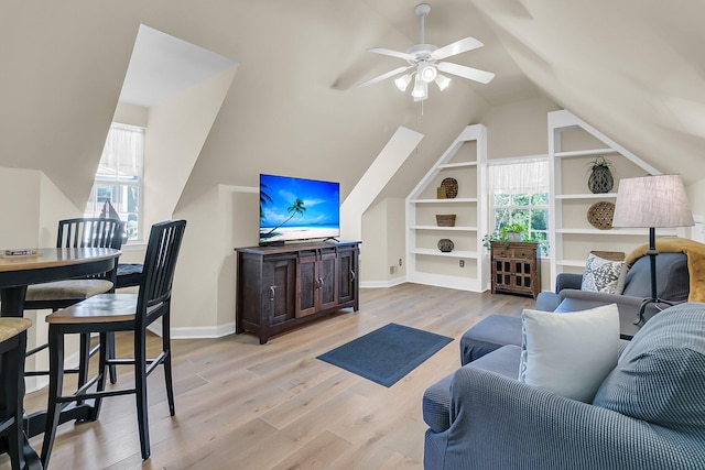 living room with a wealth of natural light, light hardwood / wood-style flooring, lofted ceiling, and ceiling fan