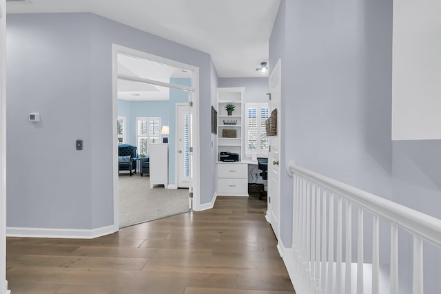 hallway with dark wood-type flooring and a wealth of natural light