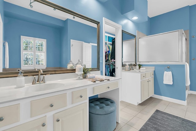 bathroom with walk in shower, tile patterned flooring, and vanity