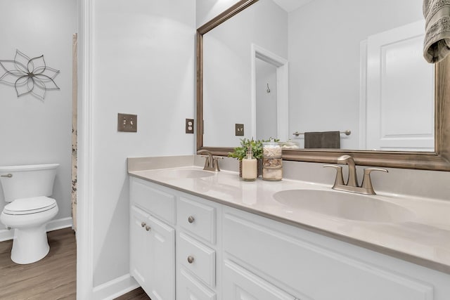 bathroom featuring wood-type flooring, vanity, and toilet