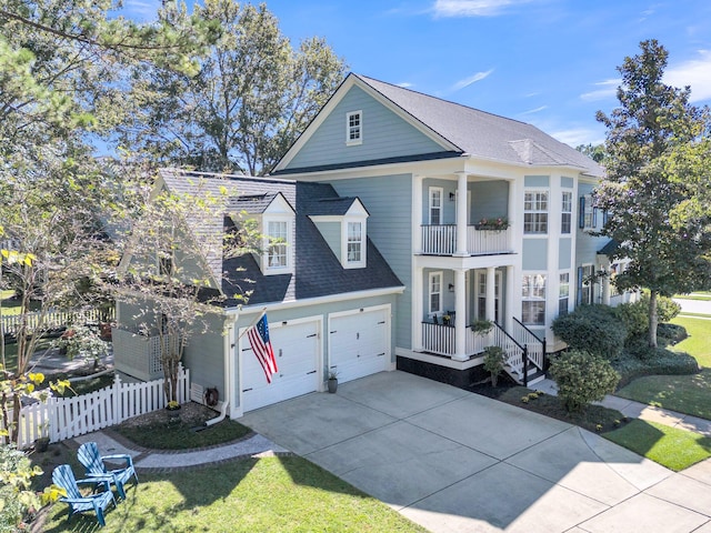 view of front of property with a garage, a front lawn, and a balcony