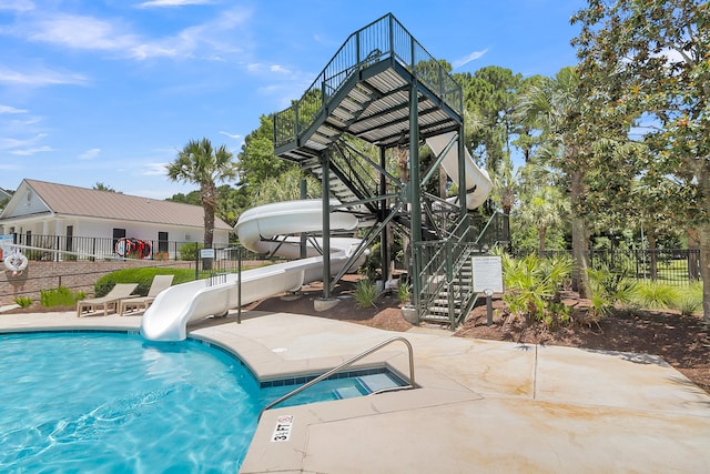 view of pool featuring a water slide and a patio