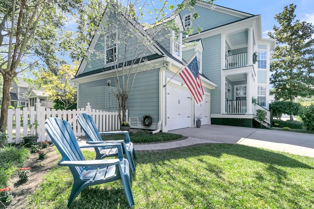 view of front of home featuring a garage, a front lawn, and a balcony