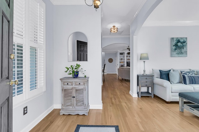 foyer entrance with hardwood / wood-style floors, ceiling fan, and crown molding