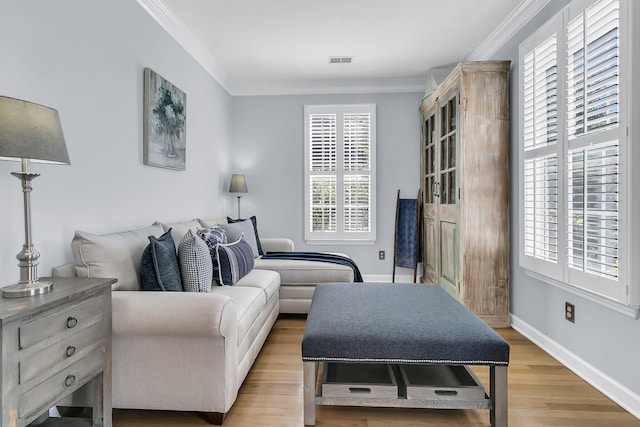 living room featuring a wealth of natural light, light hardwood / wood-style floors, and crown molding