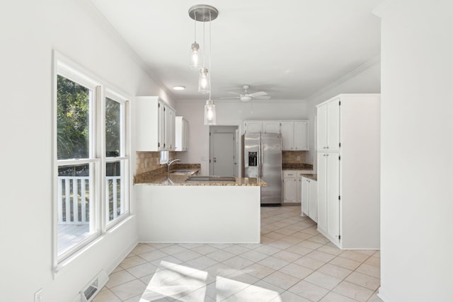 kitchen with kitchen peninsula, stainless steel refrigerator with ice dispenser, backsplash, and white cabinetry