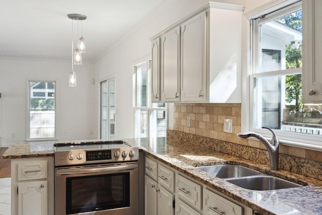 kitchen featuring sink, stainless steel range oven, white cabinetry, light stone counters, and kitchen peninsula