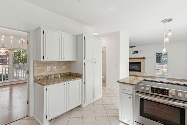 kitchen with stainless steel stove, white cabinetry, hanging light fixtures, and stone countertops