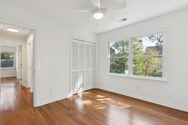 unfurnished bedroom with wood-type flooring, a closet, and ceiling fan