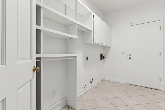 laundry room featuring washer hookup, electric dryer hookup, cabinets, and light tile patterned floors