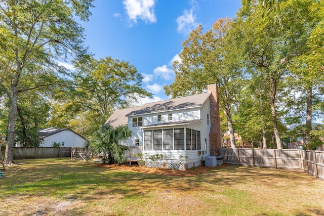 back of property with a lawn and a sunroom