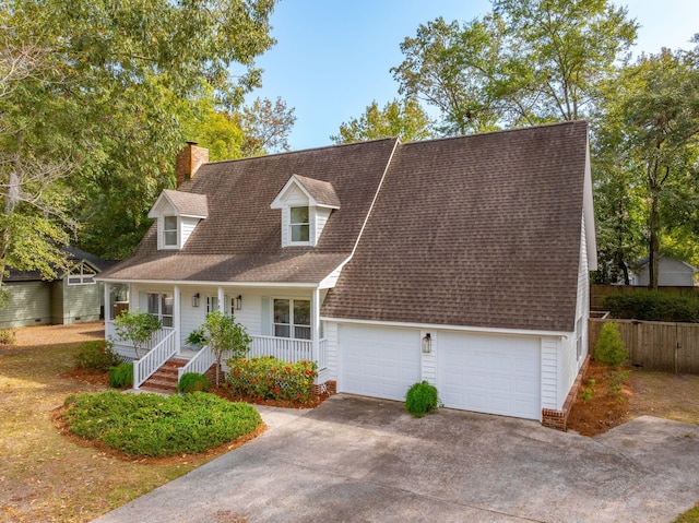 cape cod house with covered porch and a garage