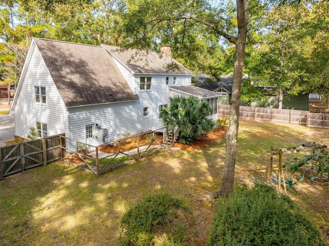 rear view of property featuring a lawn