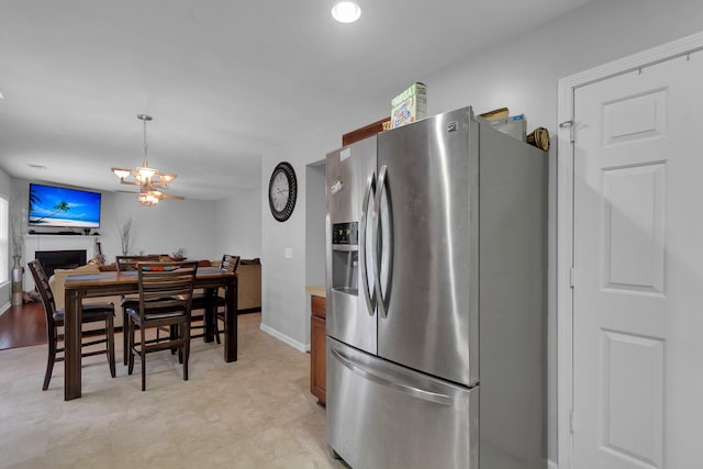 kitchen featuring a notable chandelier, hanging light fixtures, light tile floors, and stainless steel refrigerator with ice dispenser