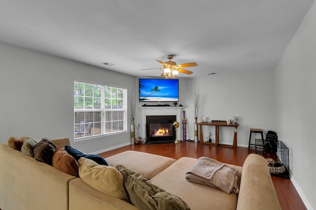 living room featuring ceiling fan and dark hardwood / wood-style floors