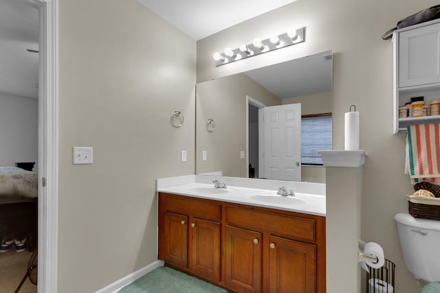 bathroom with dual sinks, toilet, and large vanity