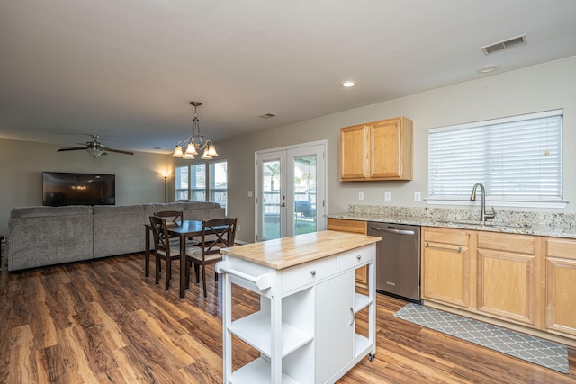 kitchen featuring sink, light stone counters, dark hardwood / wood-style flooring, and stainless steel dishwasher