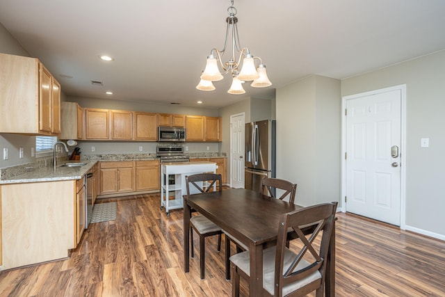 dining area with sink, a chandelier, and dark hardwood / wood-style floors