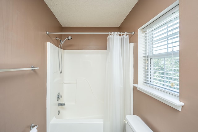 bathroom featuring toilet, a textured ceiling, and shower / bath combo with shower curtain