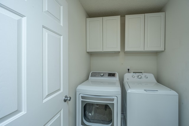 washroom featuring independent washer and dryer, a textured ceiling, and cabinets