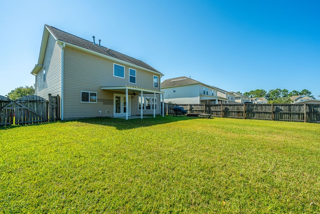 rear view of property featuring a patio area and a yard