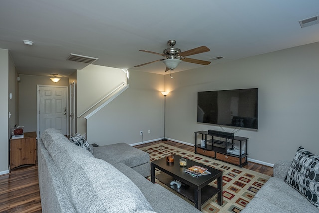 living room featuring dark wood-type flooring and ceiling fan