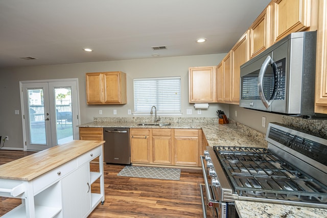 kitchen featuring appliances with stainless steel finishes, sink, french doors, light brown cabinets, and dark hardwood / wood-style floors