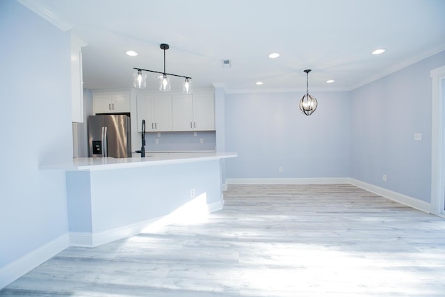 kitchen with baseboards, stainless steel fridge with ice dispenser, light countertops, white cabinetry, and crown molding