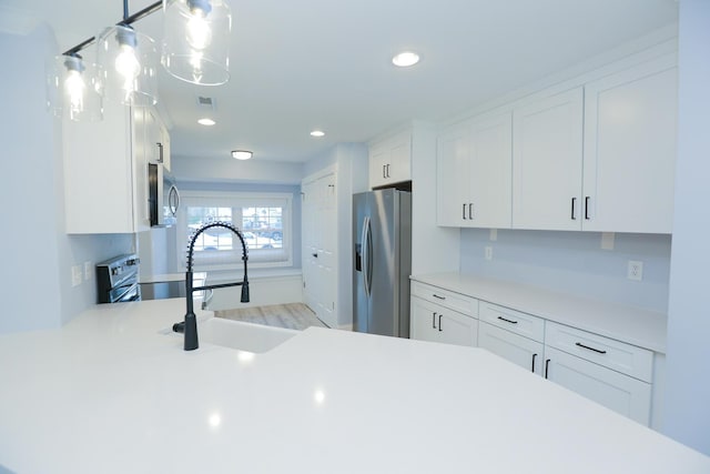 kitchen featuring white cabinetry, light countertops, appliances with stainless steel finishes, and a sink