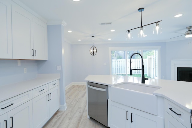 kitchen with stainless steel dishwasher, decorative light fixtures, ornamental molding, and a sink