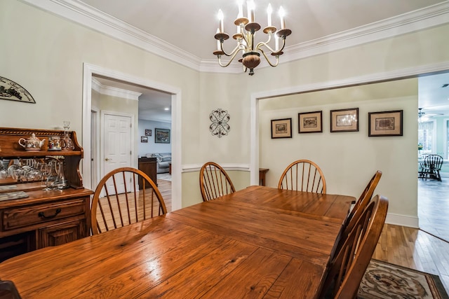 dining space featuring hardwood / wood-style flooring, an inviting chandelier, and ornamental molding