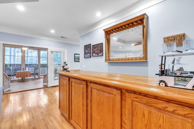 interior space featuring french doors, ornamental molding, light wood-type flooring, and wood counters