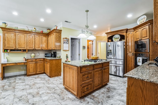 kitchen featuring hanging light fixtures, light stone countertops, ornamental molding, appliances with stainless steel finishes, and a kitchen island