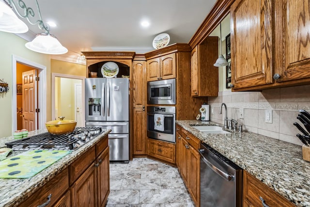 kitchen featuring light stone countertops, appliances with stainless steel finishes, hanging light fixtures, and sink