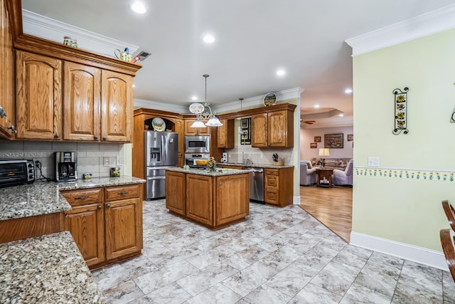 kitchen with ceiling fan, a center island, light stone counters, pendant lighting, and appliances with stainless steel finishes