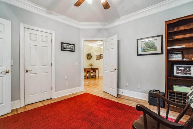 living area with hardwood / wood-style flooring, built in shelves, ceiling fan, and ornamental molding