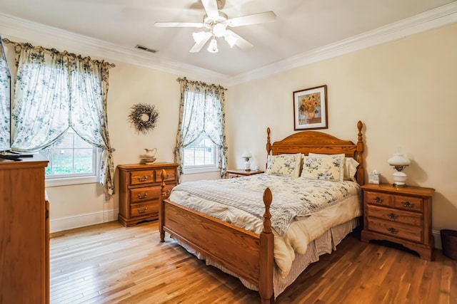 bedroom featuring hardwood / wood-style flooring, ceiling fan, crown molding, and multiple windows