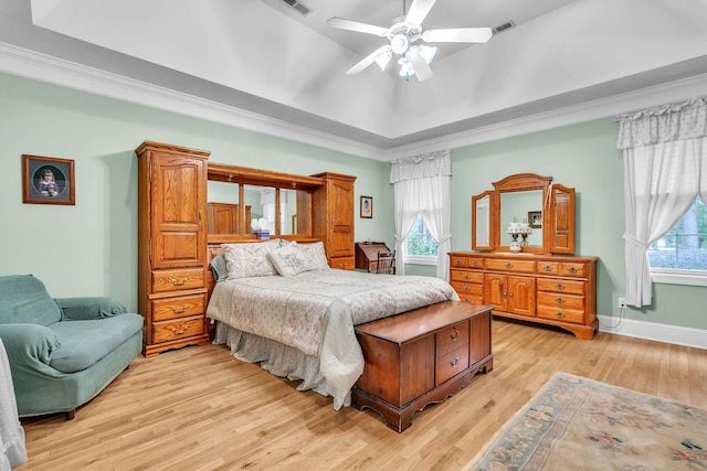 bedroom with a tray ceiling, ceiling fan, and light hardwood / wood-style flooring