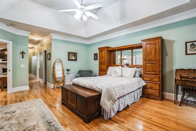 bedroom with ceiling fan, light hardwood / wood-style floors, a raised ceiling, and crown molding