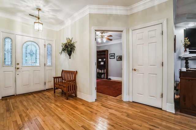 foyer entrance featuring ceiling fan, light wood-type flooring, and crown molding