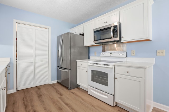 kitchen with stainless steel appliances, a textured ceiling, light hardwood / wood-style flooring, and white cabinets