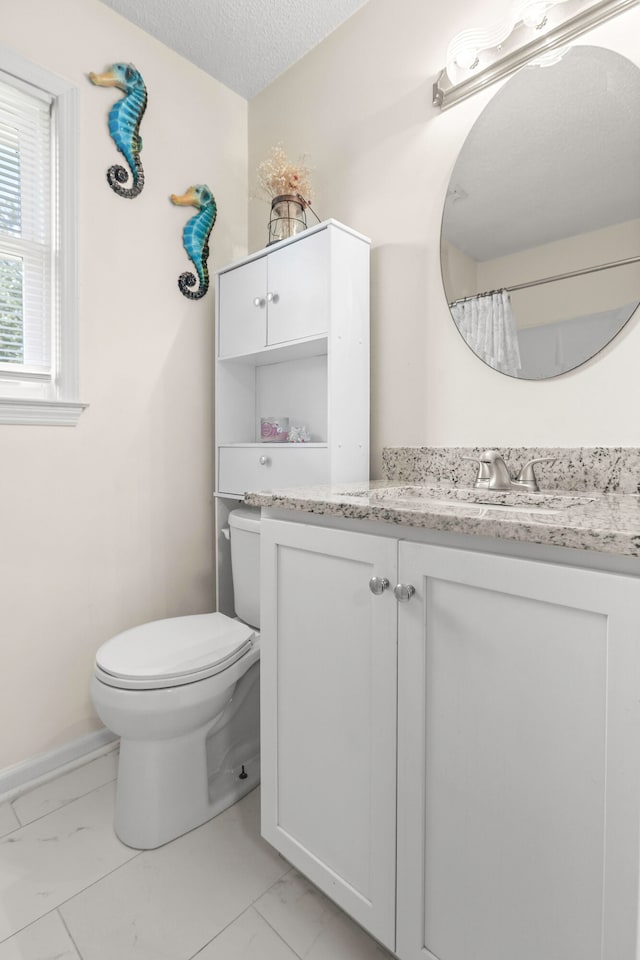 bathroom with vanity, a textured ceiling, and toilet