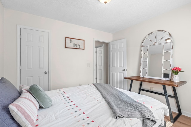 bedroom featuring hardwood / wood-style floors and a textured ceiling