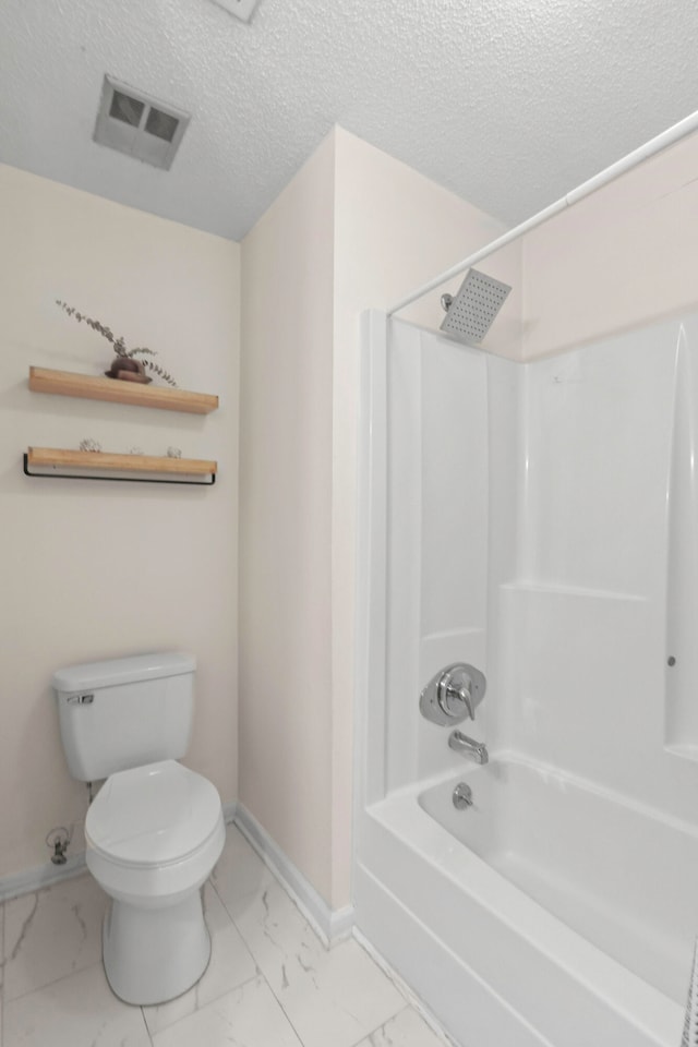 bathroom with toilet, a textured ceiling, and bathing tub / shower combination