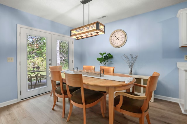 dining room featuring light hardwood / wood-style flooring and french doors