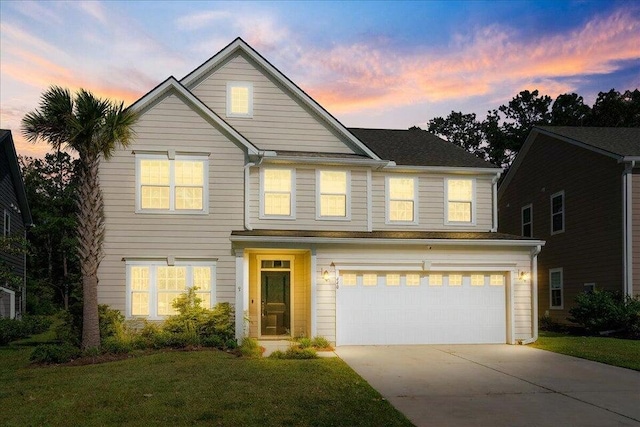 front of property with a yard and a garage